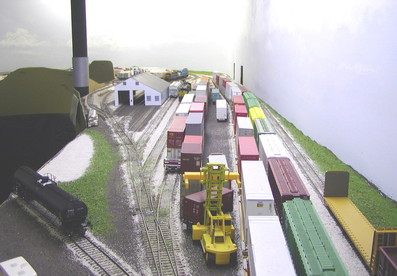 Looking south (timetable east) at Bluffs yard and the new enginehouse.  To keep the scene from being too deep to reach in, I condensed the prototype's two rip tracks that run to the right of the enginehouse into one that stubs against it.