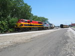 The steam freight  has pulled into the yard and the KCS detour is departing off the BN main.