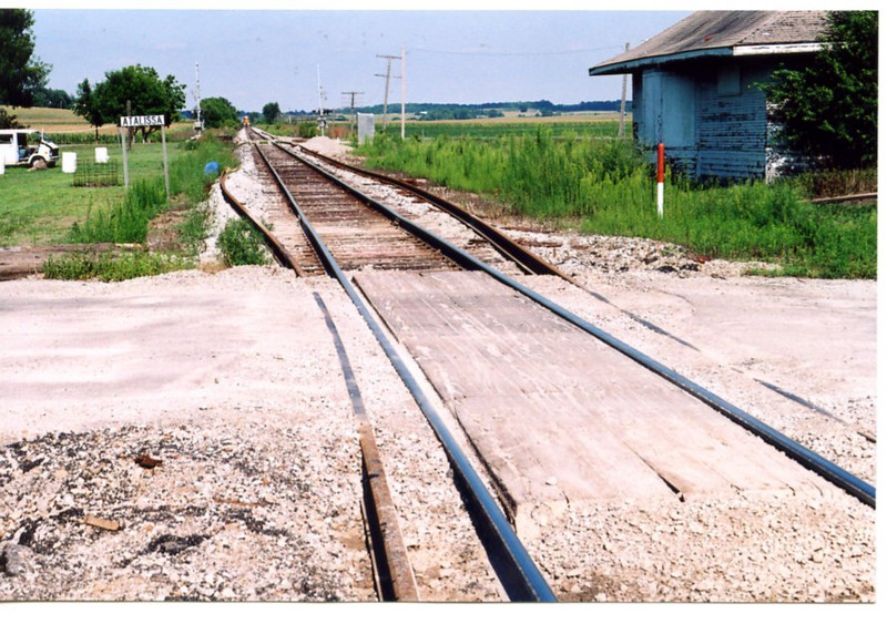 New rail ready to go in at Atalissa.  A westbound is visible in the distance,  Aug. 2005.