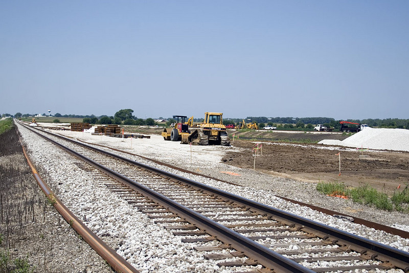 Looking west from 2900E crossing.  New rail ready for mainline and land graded for new yard north of mainline and siding.   August 10, 2007.