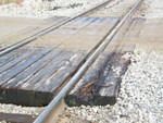 This gouged plank on the Hinkeyville crossing, mp212.5, makes it appear that the damaged axle was already off the rail at this point.