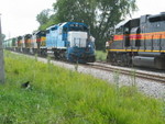 Conductors climb aboard their respective trains while Shugie inspects the weeds.