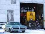 IAIS 151 peaking out from with the Iowa City engine house, along with a vintage 1960's Pontiac.