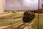 Looking west from the the CBGR grade crossing at the west end of Bluffs yard, with the BNSF main crossing from left to right, CBEC/CBGR to the left (pink ballast paralleling the IAIS), and BNSF KC yard west lead further in the distance, passing under the container chassis of the truck at the crossing.