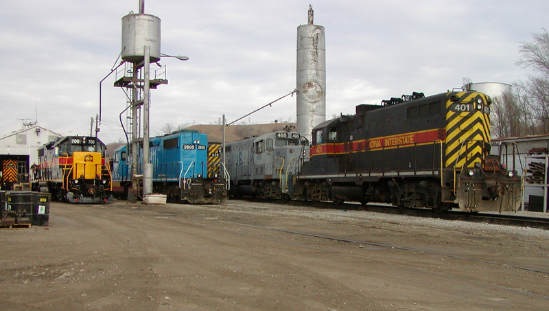 IAIS 713 (in the enginehouse) and 700, fresh from Mid American Car in Kansas City, are set up for service in Council Bluffs on December 30, 2004.  LLPX SD38-2 2805 idles alongside the road power just in from that morning's Blue Island-Council Bluffs train.