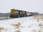 East train arrives at the east end of Twin States to pick up feed hoppers; the rest of their train is out of sight on the main behind the feed cars in the background.