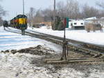 After lining the switch back, the RI conductor walks back to his train.