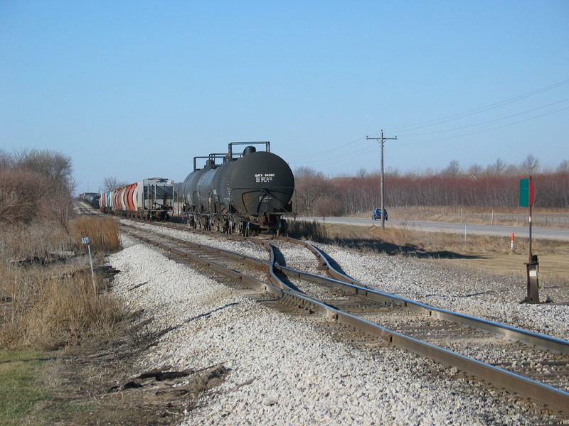 East end of Twin States siding, with acid tanks, potash loads, and in the background, Crandic setout traffic off the westbound.  That half milepost is 203.5; Feb. 8, 2006.