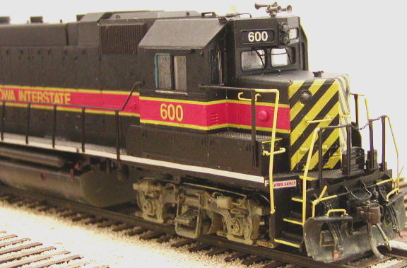 Front view showing extended cab face and cab roof modifications. Barely visible over the engineer's side front window, below the roof extension, is the conduit running out of the cab face and up to the EOT antenna. Note that the horizontal red/yellow stripe is several inches too low, as per the prototype. The standard IAIS scheme has the top yellow stripe falling on the bottom edge of the cab side windows.
