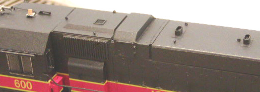 Roof view showing air filter modifications and cab roof detail. IAIS 600 started life with a squared air filter box such as that provided with the Atlas GP38, but received roof modifications and was retrofitted with the newer angled-style box in 1999 after an electrical fire. It was this work that led to the unit being repainted by an outside contractor, and it's at that time it received the OLS logo and incorrect low stripes.
