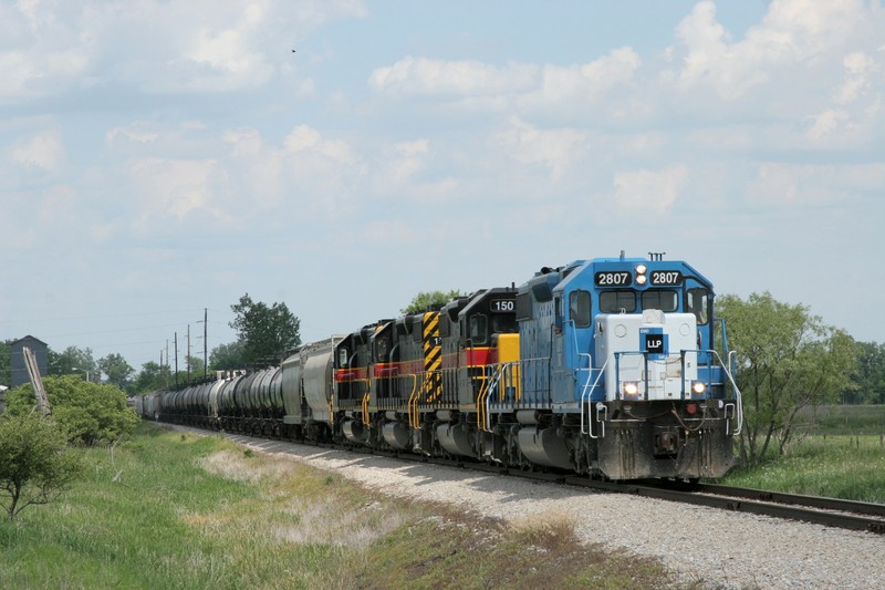 Another few miles, another one of the Amana Colonies.  Here the train is coming through Amana and about to cross US 151