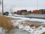 Steam train is backing westward out of Bluffs yard past the intermodal tracks.
