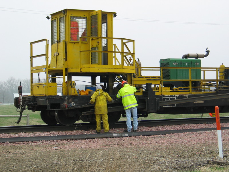 The rail crew is winching the new rail back into position to anchor it to the existing rail.