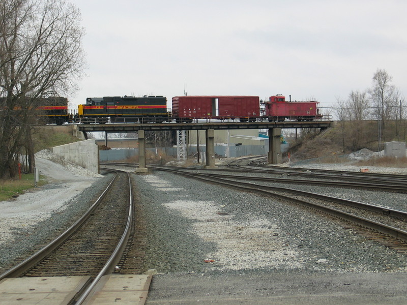 Looking south from Broadway St. in Blue Island, as IAIS transfer job shoves back toward Blue Island, with a boxcar and caboose trailing the power.