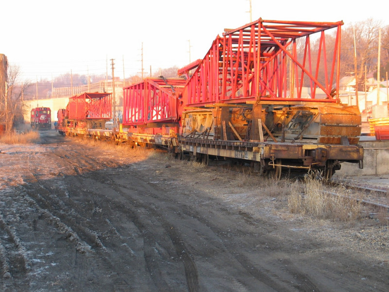 A Manitowoc track crane loaded on several flatcars, on the Ill. Railnet at Lasalle.  In the background are their CF7s; in the far distance is the old Westclox building.  Feb. 14, 2006.