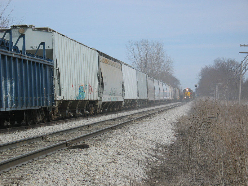 West train approaching the Wilton Pocket; covered  hoppers are storage plastic for JM. March 19, 2006.