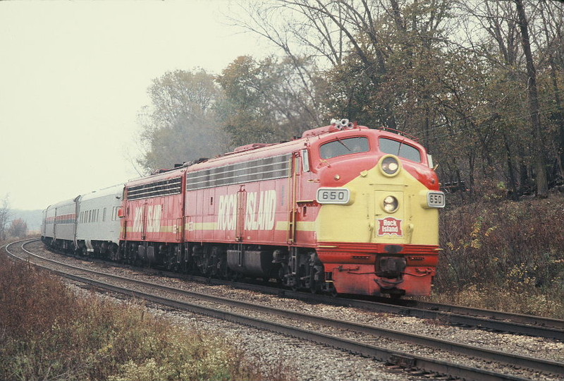 Football special on the mp214 curve east of Atalissa, Oct. 12, 1974.  This location is inaccessible by car; Rich must've hiked in from the road crossing east of here.  Notice the (mostly) welded rail on the westbound main (the train is running wrong main for some reason); this rail is still in place today, part of a RI installation from mp211 in Moscow to mp 215.5 just east of Atalissa.