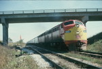 Westbound football special at the Wilton overpass, Oct. 20, 1973.  This scene is essentially the same today, with the exception of the aluminum guard rail on the overpass being replaced by a concrete one during a widening project 10 years ago or so, welded rail is now in place on the track the train is on, and the former westbound main in the immediate foreground is now part of N. Star siding.