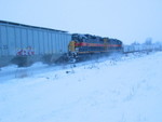 Going past JM storage cars parked on the siding.