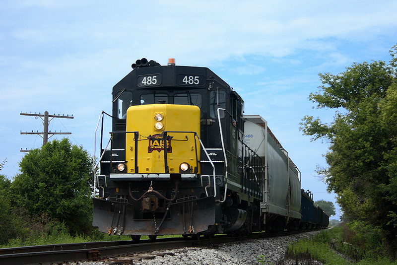 485 hustles eastbound out of Iowa City with the Wilton Turn, and scrap gons for Gerdau Ameristeel's mini-mill at Wilton. August 7th, 2006