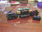 Athearn trucks (modified to lower the frame as described at http://forum.atlasrr.com/forum/topic.asp?TOPIC_ID=58609 ) and Kato motor in place, using the stock Athearn driveshafts.  The Kato motor simply screws into the Athearn fuel tank, and the mounting holes align perfectly.  This also shows the decoder and speaker installation, both of which were very easy.  

As a result of the test-fit of the shell, after this photo was taken I unscrewed the decoder, removed about 3/32" off the height of each of the motor mount "towers" that it screws into, and replaced the decoder.  Once this was done, the motor, decoder, and speaker fit perfectly inside the Athearn shell with no other modifications.