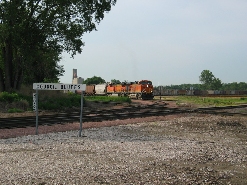 BN is delivering empty hoppers to IAIS at Bluffs yard, backing into IAIS's yard.  June 21, 2006.