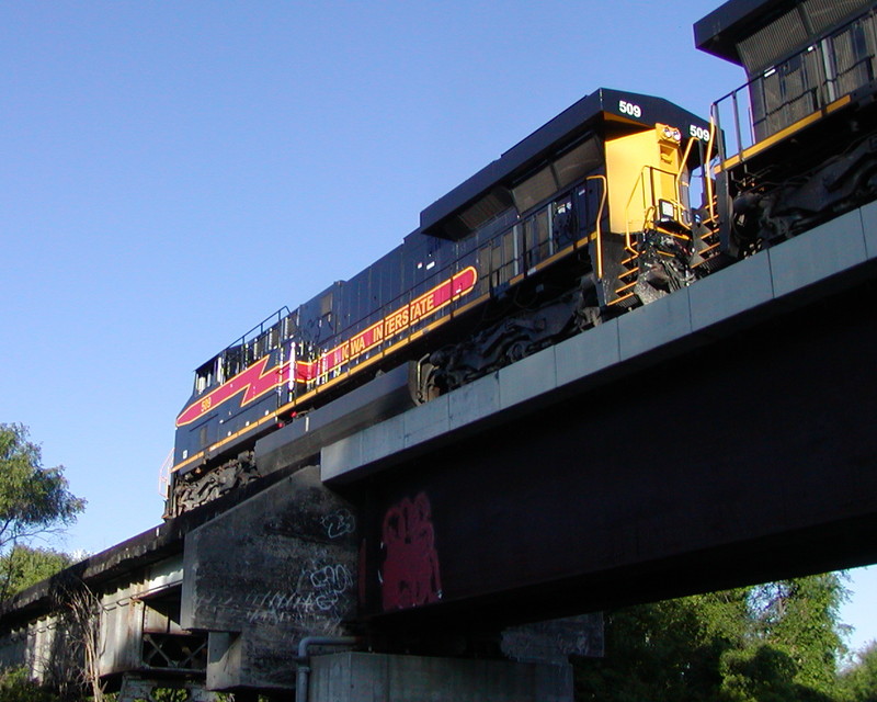 I set up a perfectly nice, dark-as-night, poorly-composed shot of the Valley View Dr. bridge in Council Bluffs, and this darn GE slips in and ruins it. ;-)  BICB arrives Bluffs around 0745 behind 509-511-703, with the sun just peeking up over the trees behind me enough to at least cast some light on the power.  Their train consisted of the empty rail flats, a huge batch of ethanol empties, a small cut of NRI and DSRC wheat empties, and pigs, including a few new Werner reefers.