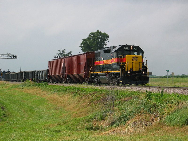 Eastbound Wilton Local at the highway 6 crossing west of West Lib., with 2 fertilizer loads for Atalissa on the head end, June 18, 2007.