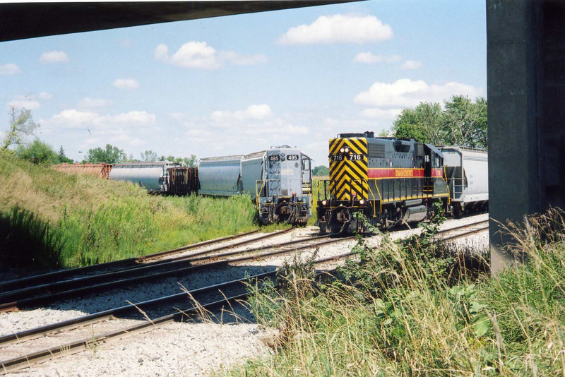 495 and 716 at the JM switch.  495 is dead; the local crew is preparing to roll it and the following cars down onto the siding, to shove west with 716.  Behind 495 are two hoppers from JM, a ballast car, and potash hoppers for Twin States.  Aug. 16, 2005