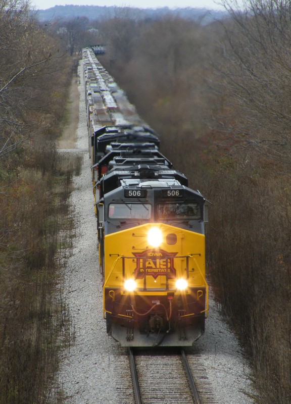 506, 703, 705, and 507 thunder up Midway Hill with a lengthy CBBI. Normally if the east train has a block of grain for Cedar Rapids, they drop it in Iowa City. Today, they left the string in the consist and will drop them off at West Liberty, thus the two extra 700's for HP up the hill.