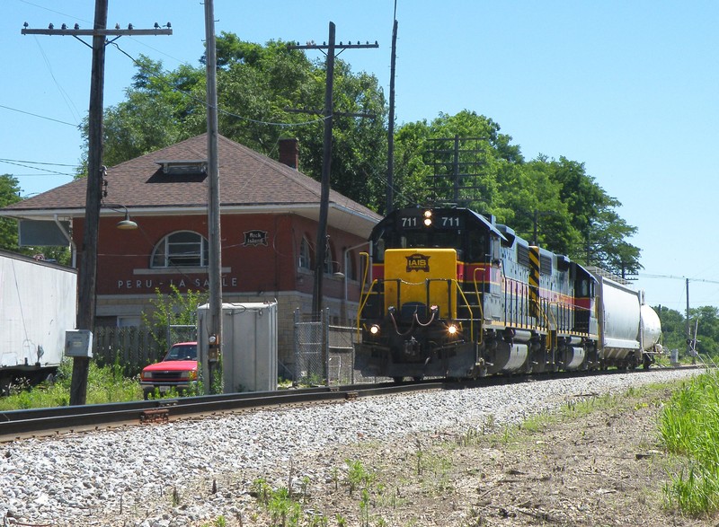 After dropping the cement loads at Buzzi, BUSW heads back west for Bureau with 2 cars from the CSX, passing the restored LaSalle/Peru depot.