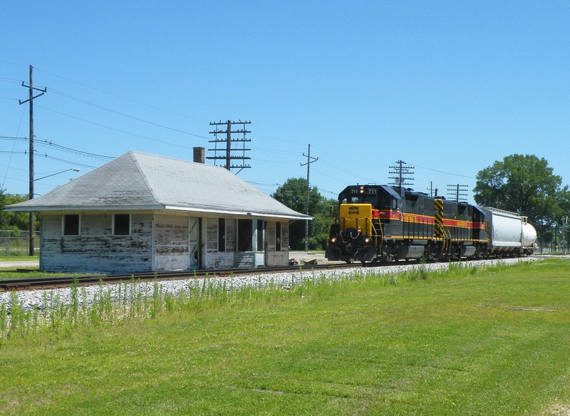 Passing through Depue, Iowa 711's RS3K screams by the old unrestored RI depot, still decked out in its final white and bankruptcy blue livery.