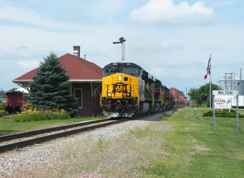 The train is screaming east at track speed as the sun pops at Wilton, IA.