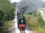 The three steam engines chuff through Wyanet under a road bridge that probably met its tonnage restriction with the amount of people on it...