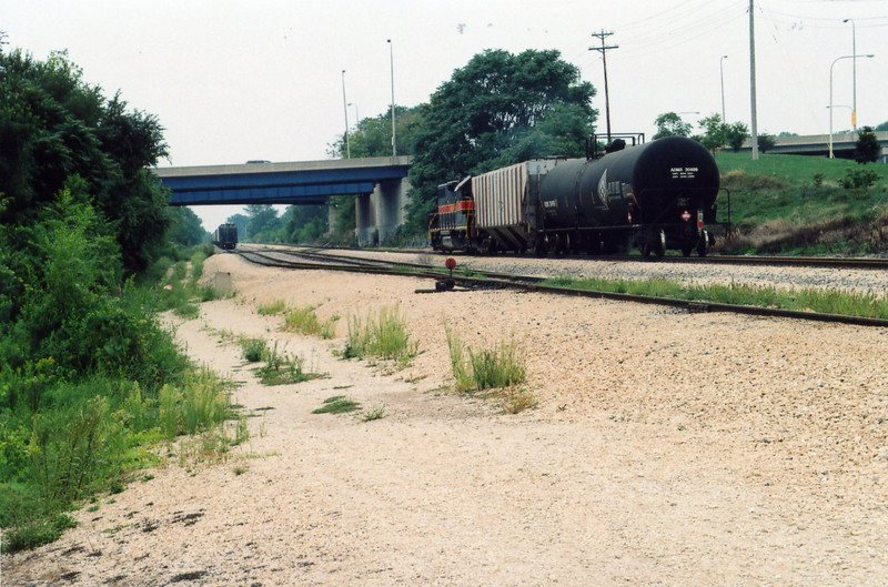 Peoria Rocket (eng 707) arrives at the north end of Limit yard, Aug. 26, 2005, under the McLuggage Bridge.  On the left are 27 empties to go back north.