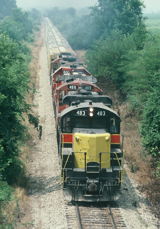 483, 469, 600, and another Geep handle a grain train east of Iowa City. August-1989.